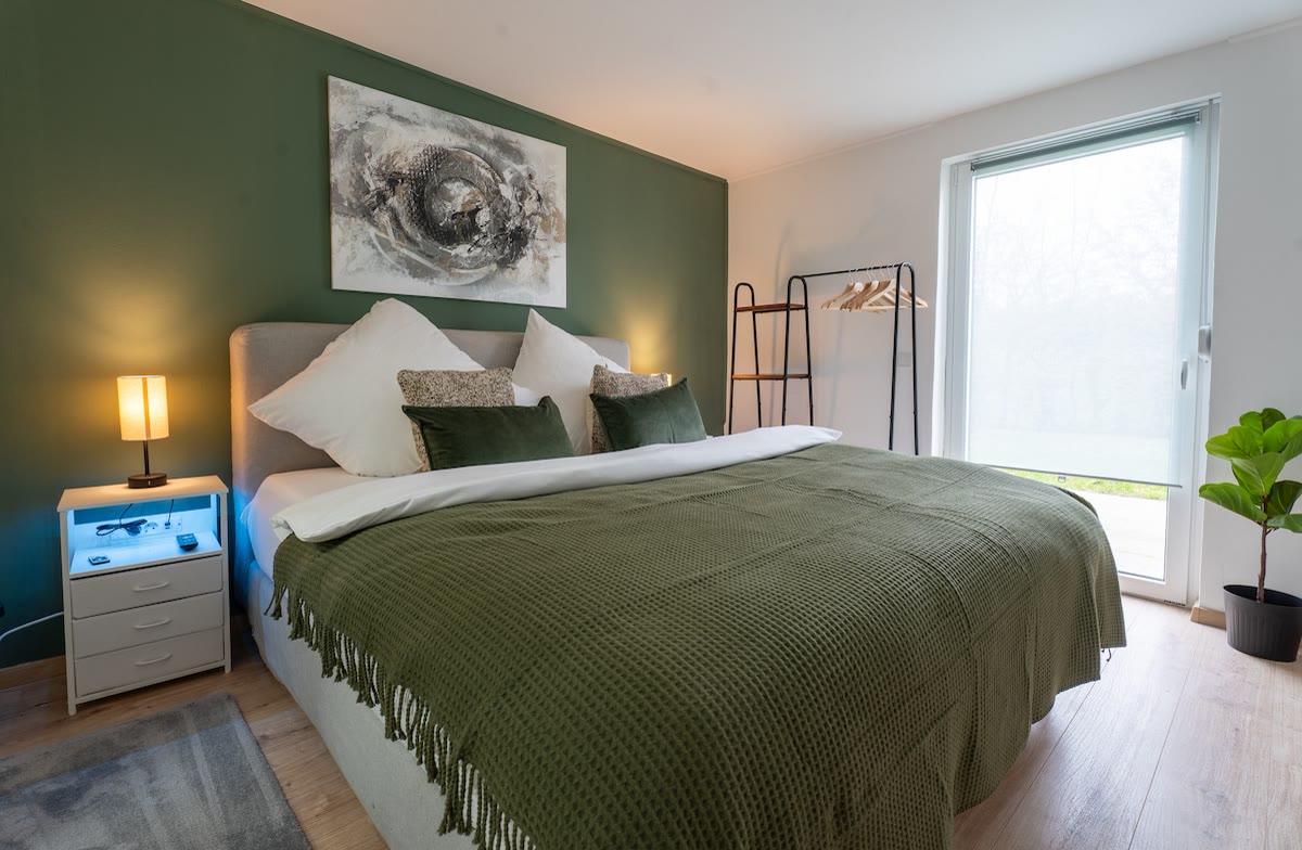 Schlafzimmer mit salbeigrüner Wand in Apart79 in Hamm-Heessen