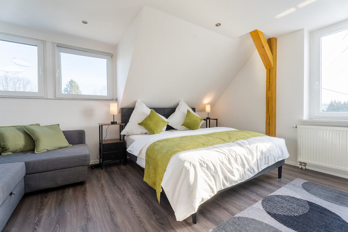 Schlafzimmer mit grüner Decke unter Holzbalken in der Doppelhaushälfte in Drensteinfurt